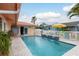 Private in-ground pool features a tiled water feature with seating and umbrella at 3235 Seaway Dr, New Port Richey, FL 34652