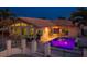 Exterior view of home featuring a swimming pool and outdoor living space illuminated at dusk, perfect for relaxation and entertainment at 3235 Seaway Dr, New Port Richey, FL 34652