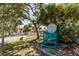 Scenic street view of a private beach club with lush landscaping, palm trees, and a glimpse of charming coastal homes at 3235 Seaway Dr, New Port Richey, FL 34652