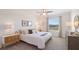 Bright main bedroom featuring a ceiling fan, large window, and stylish furnishings at 3516 Marigold Patch Ct, Plant City, FL 33565