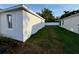 Side yard of home with green grass and white privacy fence in the back at 37565 Teri Ct, Dade City, FL 33525