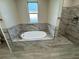 Bathtub with marble tile and window at 37565 Teri Ct, Dade City, FL 33525