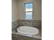 Bathtub features marble tile and a window at 37565 Teri Ct, Dade City, FL 33525
