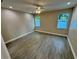 Bedroom featuring hardwood floors, natural light from the large window, and a ceiling fan at 37565 Teri Ct, Dade City, FL 33525