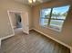 Bright bedroom featuring wood-look tile flooring, a ceiling fan, and a large window offering ample natural light at 37565 Teri Ct, Dade City, FL 33525