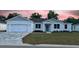 Charming single-story home featuring a well-manicured lawn and a brick-paved driveway and a modern, white facade at 37565 Teri Ct, Dade City, FL 33525