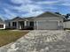 Home exterior with stone accents, large garage and a paved driveway at 37565 Teri Ct, Dade City, FL 33525