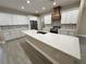 Well-lit kitchen featuring a spacious island, stainless steel appliances, white cabinetry, and modern countertops at 37565 Teri Ct, Dade City, FL 33525