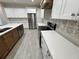 A kitchen featuring stainless steel appliances, white cabinets, decorative backsplash, and light countertops at 37565 Teri Ct, Dade City, FL 33525