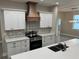 A kitchen featuring a dark wood vent hood, modern appliances, light countertops, and white cabinets at 37565 Teri Ct, Dade City, FL 33525