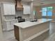Well-lit kitchen showcasing white cabinets, stainless steel appliances, and a large island with sink at 37565 Teri Ct, Dade City, FL 33525