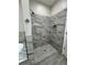 Modern shower with marble tile, pebble floor, and niche at 37565 Teri Ct, Dade City, FL 33525