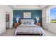Comfortable main bedroom with dark blue accent wall, neutral decor, and lots of natural light at 4033 Westwood Fields Loop, Plant City, FL 33565