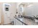 Bright bathroom featuring a granite countertop, white cabinetry, and decorative mirror, with neutral paint and tile at 4039 Westwood Fields Loop, Plant City, FL 33565