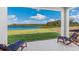 Covered patio with serene views of a lush green lawn and tranquil lake on a sunny day at 4039 Westwood Fields Loop, Plant City, FL 33565