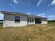 Backyard showcasing the home's exterior, an open patio, and a spacious lawn area ready for landscaping at 4294 Cork Rd, Plant City, FL 33565
