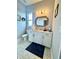 Clean bathroom featuring a white vanity, unique tile floors, and decorative mirror at 4294 Cork Rd, Plant City, FL 33565