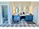Lovely bathroom with blue vanity cabinets, unique tile floors, and decorative mirrors at 4294 Cork Rd, Plant City, FL 33565