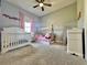Light filled bedroom offering a crib, play furniture, plush carpet and modern ceiling fan at 4294 Cork Rd, Plant City, FL 33565