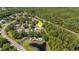 Stunning aerial view of a community featuring lush landscaping, a sparkling pool, and serene pond at 4425 Connery Ct, Palm Harbor, FL 34685