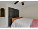 Compact bedroom featuring a wood-framed bed, closet, mirror, ceiling fan, and hardwood floors, providing storage and style at 4425 Connery Ct, Palm Harbor, FL 34685