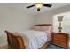 Cozy bedroom featuring a wood-framed bed, nightstand with lamp, ceiling fan, and window, creating a comfortable space at 4425 Connery Ct, Palm Harbor, FL 34685