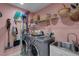 Convenient laundry room with modern washer and dryer, utility sink, storage shelf, and ample space for cleaning supplies at 4425 Connery Ct, Palm Harbor, FL 34685