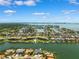 Picturesque aerial view of waterfront homes with boat docks, surrounded by lush greenery under a cloudy blue sky at 6202 Pasadena Point Blvd, Gulfport, FL 33707