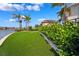 Expansive backyard featuring artificial turf, a putting green, and waterfront views at 6202 Pasadena Point Blvd, Gulfport, FL 33707
