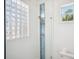 Bright white bathroom with a glass block window and a modern stand up shower at 6202 Pasadena Point Blvd, Gulfport, FL 33707