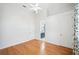 Bedroom with hardwood flooring, fan, two doors and view to a blue vanity and sink at 6202 Pasadena Point Blvd, Gulfport, FL 33707