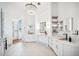Bright and airy main bathroom featuring a crystal chandelier, dual sinks, and modern fixtures at 6202 Pasadena Point Blvd, Gulfport, FL 33707