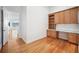 Well-lit home office with custom built-ins, desk space, and hardwood flooring at 6202 Pasadena Point Blvd, Gulfport, FL 33707