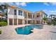 A luxurious pool in an outdoor living space of a modern home, with an open patio and beautiful water feature at 6202 Pasadena Point Blvd, Gulfport, FL 33707