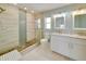 A renovated bathroom featuring a large shower with bench and double sinks with marble countertops at 6528 Santiago Ct, Apollo Beach, FL 33572