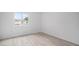 Empty bedroom featuring light wood floors and a bright window, showcasing the room's spaciousness at 6831 Dartmouth Hill St, Riverview, FL 33578