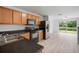 Kitchen with wooden cabinets, black appliances, and a view of the pond from the sliding glass doors at 6831 Dartmouth Hill St, Riverview, FL 33578