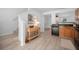 Well-lit kitchen with wood cabinets, modern appliances, new flooring, and view into the living room at 6831 Dartmouth Hill St, Riverview, FL 33578
