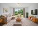 Comfortable living room with a large window overlooking the backyard pond and manicured landscaping at 6831 Dartmouth Hill St, Riverview, FL 33578