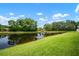 Scenic view of the pond surrounded by lush landscaping, reflecting the blue sky and white clouds at 6831 Dartmouth Hill St, Riverview, FL 33578