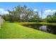 Relaxing pond view with mature trees and grassy lawn for backyard enjoyment and nature views at 6831 Dartmouth Hill St, Riverview, FL 33578