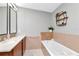 Bathroom with a soaking tub, double vanity, and tiled backsplash at 912 Channelside Dr # 2710, Tampa, FL 33602