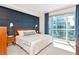 Bright bedroom featuring a queen bed, accent wall, and large window views at 912 Channelside Dr # 2710, Tampa, FL 33602