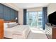 Bedroom featuring a queen sized bed, blue accent wall, and a large window at 912 Channelside Dr # 2710, Tampa, FL 33602