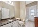 Bathroom features a marble countertop vanity, toilet, and tiled tub shower with window at 9127 Irondale Ln, Hudson, FL 34667