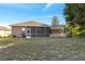 Rear view of the home showcasing the screened-in patio at 9127 Irondale Ln, Hudson, FL 34667