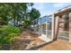 Exterior view of screened-in patio and lush landscaping at 9127 Irondale Ln, Hudson, FL 34667