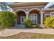 Close-up of a home's entryway with decorative columns, arched entry, and landscaped surroundings at 9127 Irondale Ln, Hudson, FL 34667