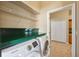 Laundry room with modern washer, dryer, cabinets and tiled floors at 9127 Irondale Ln, Hudson, FL 34667