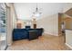 Living room with bright blue furniture, tile floors, neutral paint and access to kitchen and pool at 9127 Irondale Ln, Hudson, FL 34667